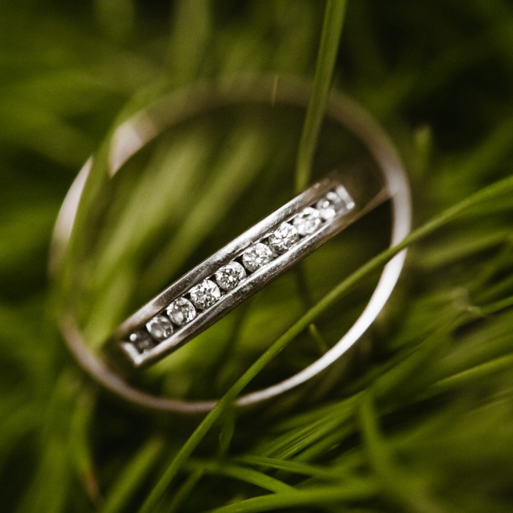 Beautiful bridal wedding rings lie one by one in the grass