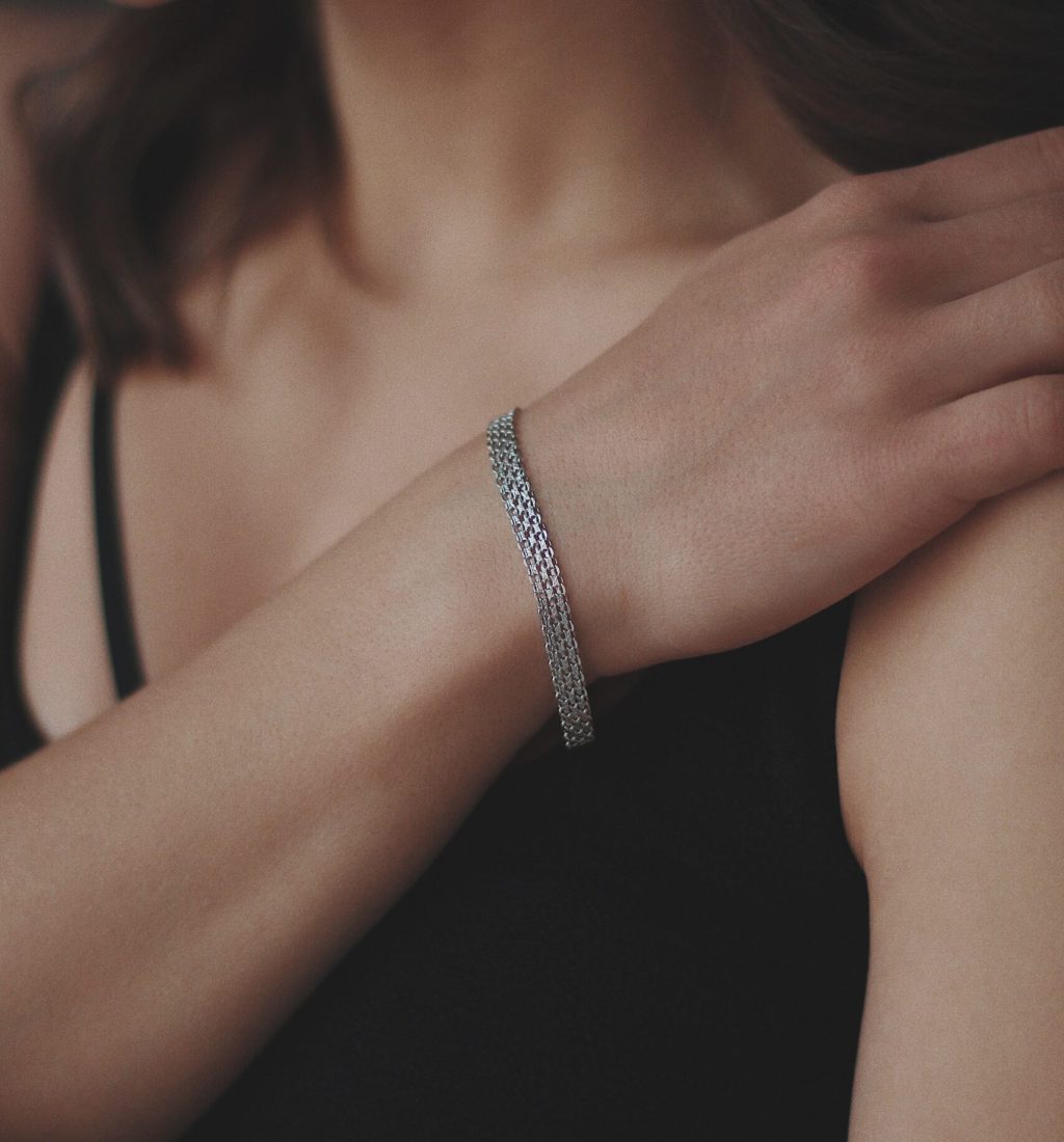 A vertical shot of a young female wearing a beautiful silver bracelet